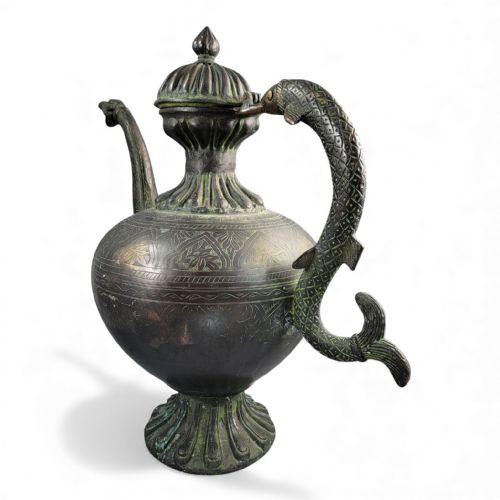 fig 4. An antique dark bronze Indian aftaba ewer featuring an engraved bulbous body, a creature-shaped spout, a fluted base, and a Makara handle.