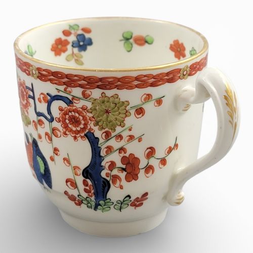 fig 1. A white porcelain teacup and matching saucer adorned with hand-painted quail birds, red and green floral foliage, and gilded rims.