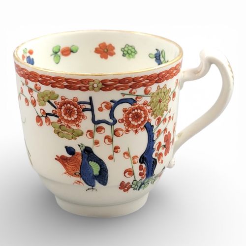 fig 3. A white porcelain teacup and matching saucer adorned with hand-painted quail birds, red and green floral foliage, and gilded rims.