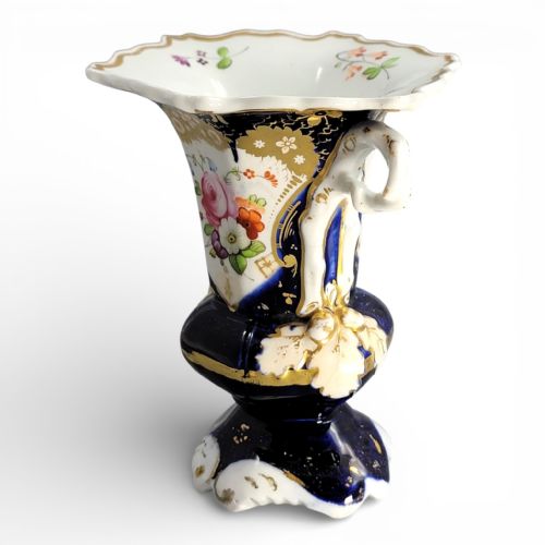 fig 2. An early nineteenth-century French porcelain vase featuring hand-painted pink floral motifs, cobalt blue glaze, twin scroll handles, and gold leaf embellishments.