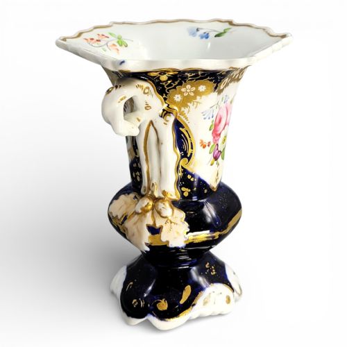 fig 4. An early nineteenth-century French porcelain vase featuring hand-painted pink floral motifs, cobalt blue glaze, twin scroll handles, and gold leaf embellishments.