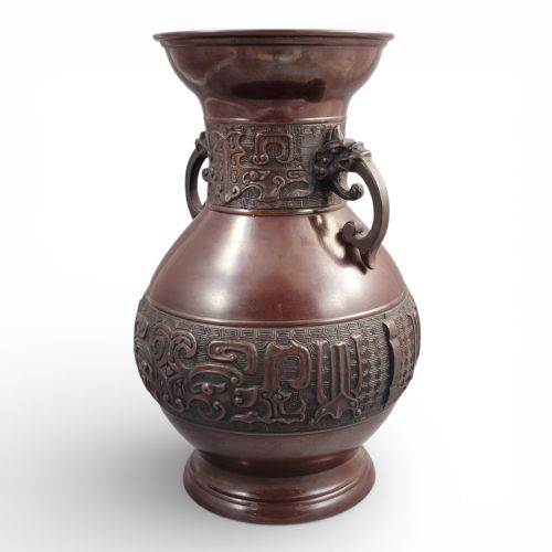 fig 1. A cast dark bronze Japanese archaistic hu vase featuring dragon head handles and intricate carved relief bands around the neck and waist.