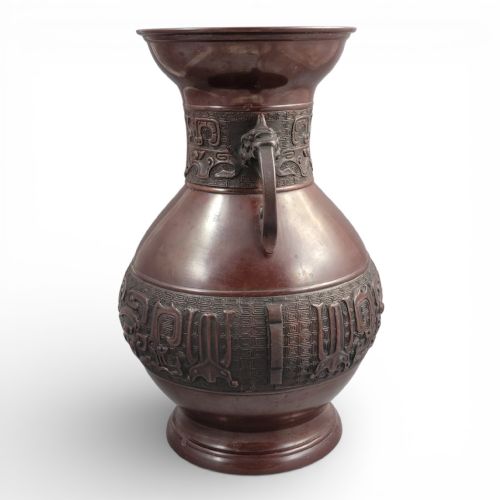 fig 2. A cast dark bronze Japanese archaistic hu vase featuring dragon head handles and intricate carved relief bands around the neck and waist.
