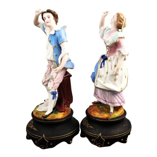 fig 2. A pair of 19th-century French porcelain figurines featuring a man and woman in 18th-century style attire on black painted bases.