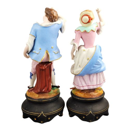 fig 3. A pair of 19th-century French porcelain figurines featuring a man and woman in 18th-century style attire on black painted bases.