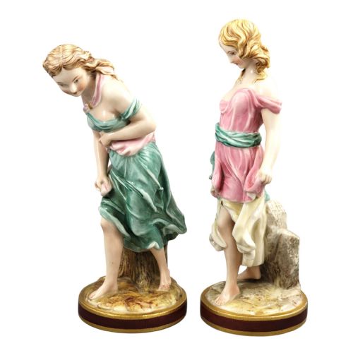fig 1. A pair of Victorian Royal Worcester porcelain figures depicting draped maidens with pink and green dresses standing on circular bases.