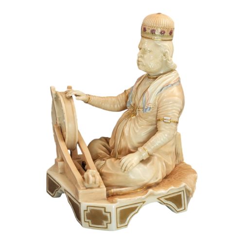 fig 1. A late 19th-century Royal Worcester blush ivory porcelain figurine depicting an Indian craftsman seated at a spinning wheel, detailed with polychrome enamel and gold gilded highlights.