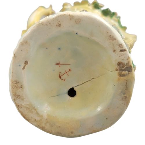 fig 4. An 18th-century Bow porcelain figurine depicting a lady in a patterned skirt and wide-brimmed hat holding flowers alongside a seated lamb.