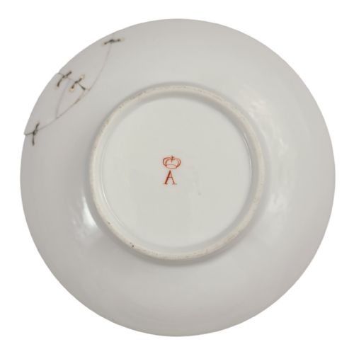 fig 3. A French Neoclassical porcelain covered trembleuse cup and saucer decorated with pink ribbons, blue floral garlands, gold leaf borders, and a cherry-shaped lid finial.