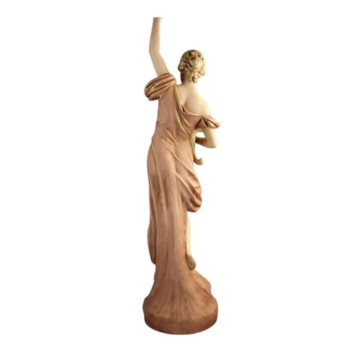 fig 3. An Art Nouveau porcelain figure depicting a maiden in flowing drapery with one arm raised aloft and holding flowers at her waist.