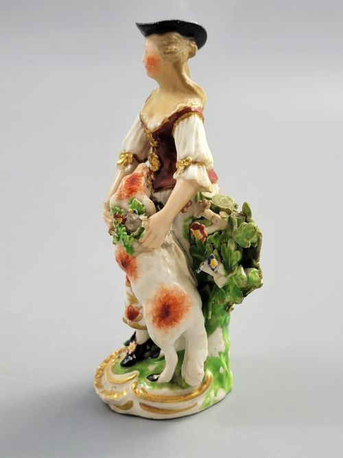 fig 2. An 18th-century Derby soft-paste porcelain figurine depicting a shepherdess with a lamb on a gilded Rococo scroll base.