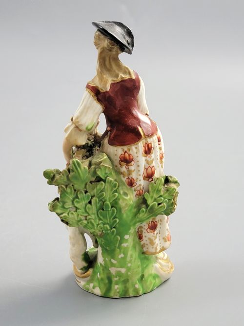 fig 3. An 18th-century Derby soft-paste porcelain figurine depicting a shepherdess with a lamb on a gilded Rococo scroll base.