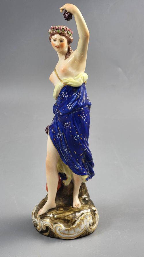 fig 1. A nineteenth-century Samson Paris porcelain figure of a Bacchante wearing a patterned cobalt blue drape and holding grapes on a scrollwork base.