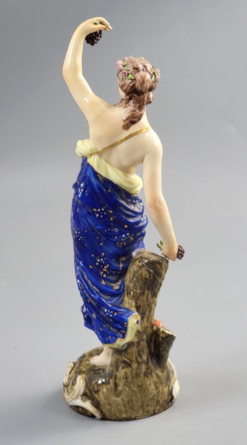 fig 3. A nineteenth-century Samson Paris porcelain figure of a Bacchante wearing a patterned cobalt blue drape and holding grapes on a scrollwork base.