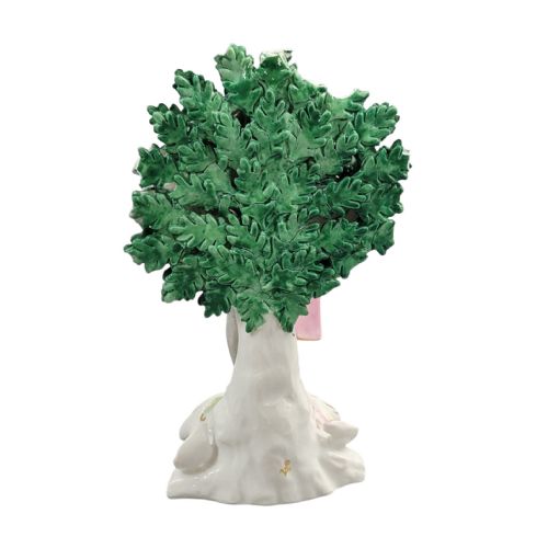 fig 3. A nineteenth-century French Samson porcelain figurine depicting a masked actor in a patterned jacket and cape standing before a flowering green tree backdrop.