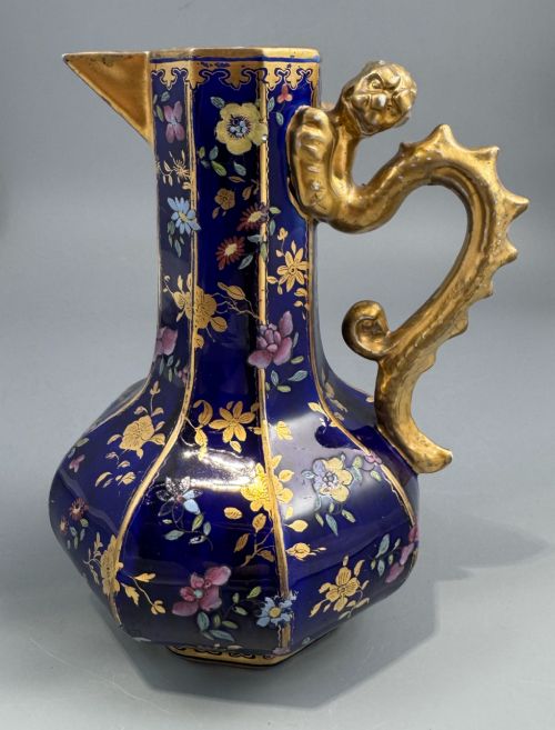 fig 2. An octagonal cobalt blue ironstone ewer decorated with hand-painted Chinoiserie floral patterns and a gilded grotesque animal form handle.