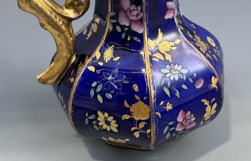 fig 4. An octagonal cobalt blue ironstone ewer decorated with hand-painted Chinoiserie floral patterns and a gilded grotesque animal form handle.