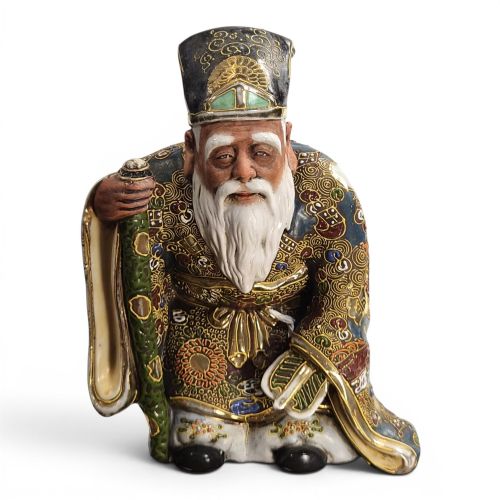 fig 1. A Japanese Kutani porcelain figurine depicting Jurojin with a long white beard holding a staff, decorated in polychrome overglaze enamels and gold details.