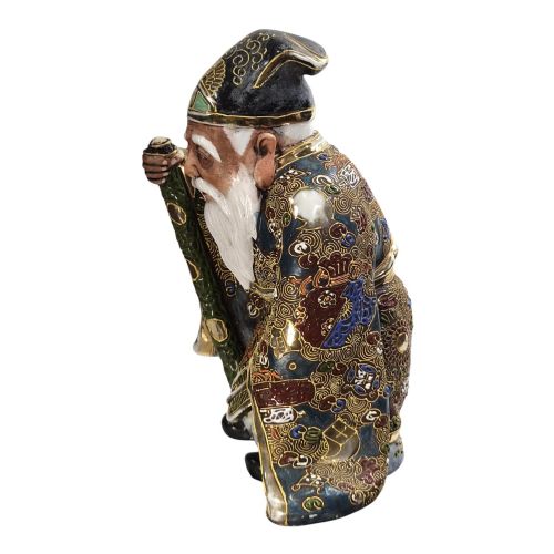 fig 2. A Japanese Kutani porcelain figurine depicting Jurojin with a long white beard holding a staff, decorated in polychrome overglaze enamels and gold details.
