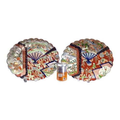 fig 1. A pair of round antique Japanese Arita Imari porcelain charger plates featuring scalloped edges, fan motifs, landscape scenes, and iron red, cobalt blue, and green enamels.