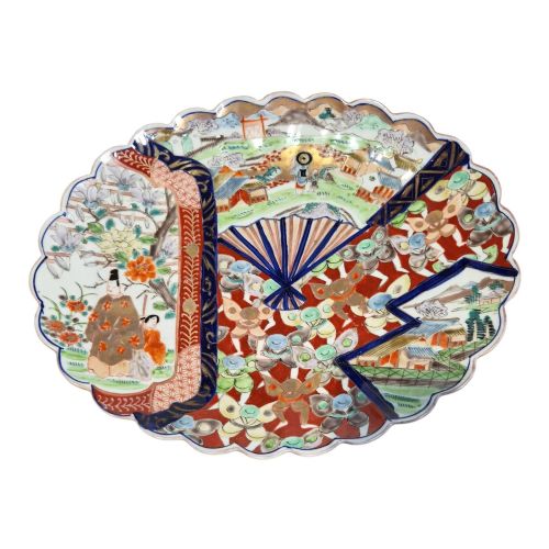 fig 3. A pair of round antique Japanese Arita Imari porcelain charger plates featuring scalloped edges, fan motifs, landscape scenes, and iron red, cobalt blue, and green enamels.