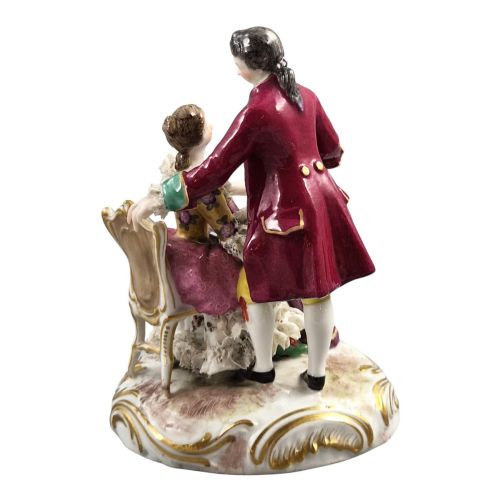 fig 3. A 19th-century Paris porcelain figural group depicting a man standing behind a seated woman playing a harp, featuring porcelain lace trim and gold scrollwork.