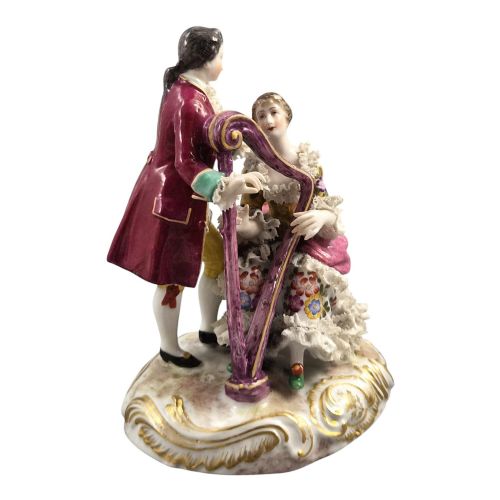 fig 5. A 19th-century Paris porcelain figural group depicting a man standing behind a seated woman playing a harp, featuring porcelain lace trim and gold scrollwork.