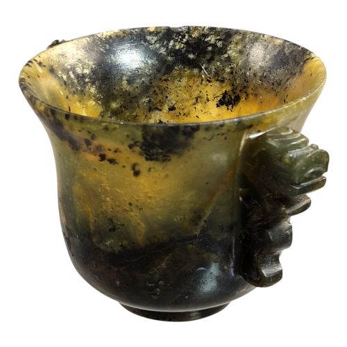 fig 1. A hand-carved mottled olive-green and dark ochre nephrite jade cup featuring carved handles on either side.