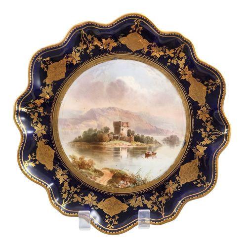 fig 1. A set of four late nineteenth-century Aynsley porcelain cabinet plates featuring hand-painted landscape scenes surrounded by cobalt blue rims with heavy gold foliage gilding.
