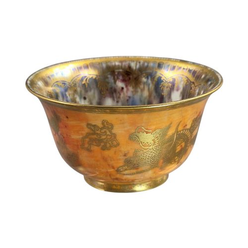 fig 2. An antique ceramic bowl with a mottled orange lustre glaze on the exterior, decorated with a gold gilded dragon, and a pearlescent interior with a gilded scalloped border.