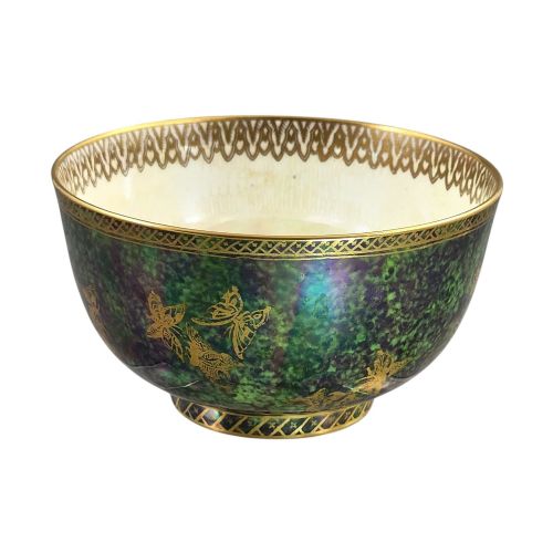 fig 2. A deep porcelain bowl featuring a mottled green iridescent exterior decorated with gilded butterflies and geometric gold borders around the rim and base.