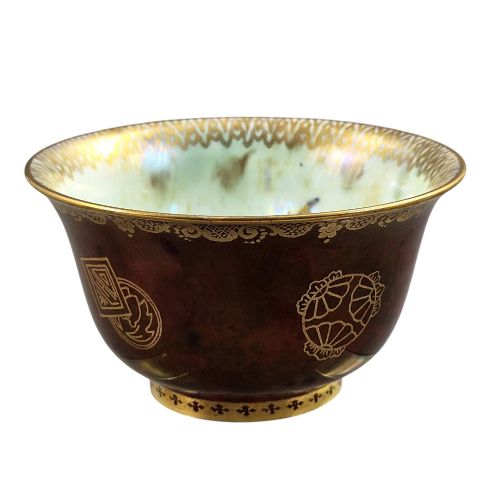 fig 1. A deep red ceramic bowl with a flared rim, featuring gilded motifs on the exterior and an iridescent opalescent glazed interior.