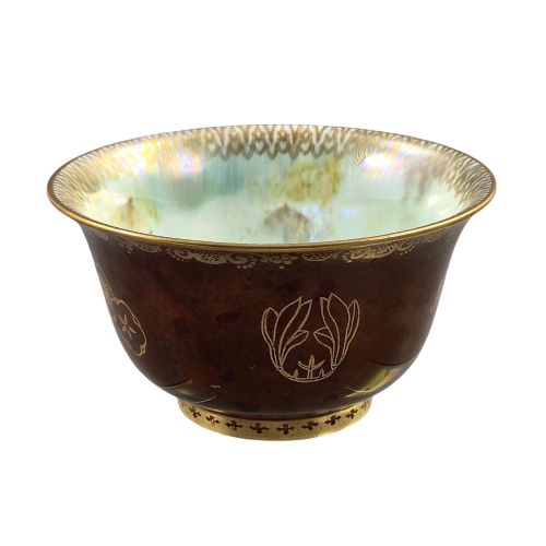 fig 3. A deep red ceramic bowl with a flared rim, featuring gilded motifs on the exterior and an iridescent opalescent glazed interior.