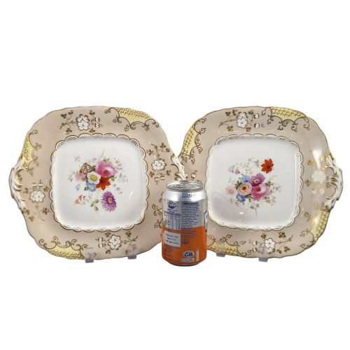 fig 2. A pair of early Victorian Coalport porcelain square dessert dishes featuring hand-painted floral centres, beige borders with gold scrollwork, and moulded twin handles.