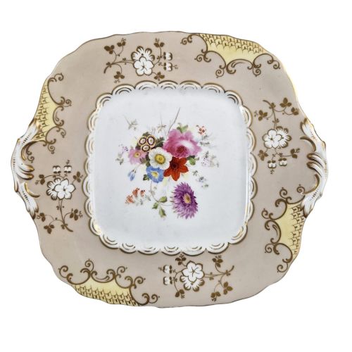 fig 3. A pair of early Victorian Coalport porcelain square dessert dishes featuring hand-painted floral centres, beige borders with gold scrollwork, and moulded twin handles.