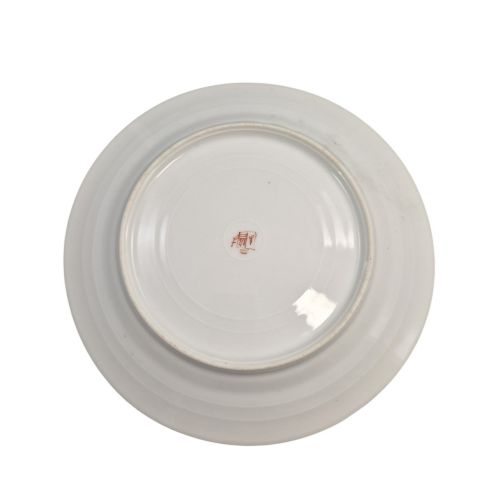 fig 4. A pair of circular white porcelain plates featuring a central coat of arms, hand-painted floral sprays, raised enamel details, and gilded rims.