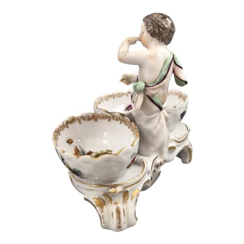 fig 2. A 19th-century German hard-paste porcelain double salt cellar featuring a central sculpted figure of a cherub flanked by two shell-shaped bowls hand-painted with birds and insects.