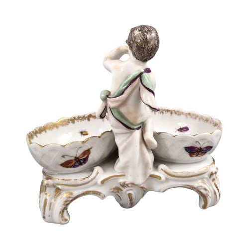 fig 3. A 19th-century German hard-paste porcelain double salt cellar featuring a central sculpted figure of a cherub flanked by two shell-shaped bowls hand-painted with birds and insects.