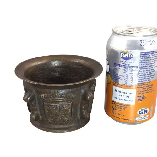 fig 4. A heavy 17th-century cast bronze apothecary mortar featuring raised heraldic coat of arms motifs and side lugs around a flared rim.