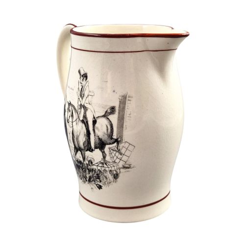fig 2. A Georgian creamware jug featuring a black transfer-printed hunting scene and terracotta red painted rim accents against a cream glaze.