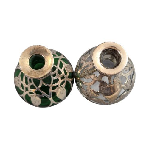 fig 5. A pair of Art Nouveau perfume bottles featuring detailed sterling silver overlay in intricate floral lattice patterns on green and clear glass bases with matching glass stoppers.