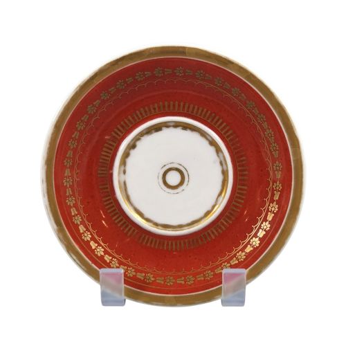 fig 1. A red and gilded French Empire porcelain cabinet cup and matching saucer featuring a raised white lion mask handle detail.