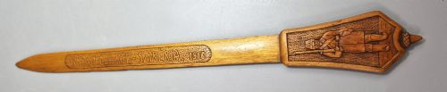 fig 1. A hand-carved wooden letter opener featuring a relief carving of a soldier on the handle and carved text reading Krasnojarsk Sziberia 1916 on the blade.