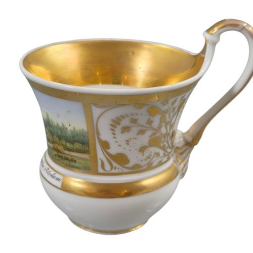 fig 1. A 19th-century KPM Berlin porcelain cabinet cup with a fully gilded interior, high curved loop handle, and hand-painted topographical view of Peacock Island.