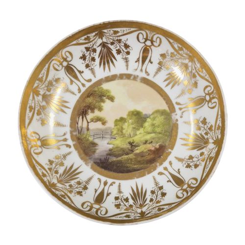 fig 1. An early nineteenth-century KPM Berlin porcelain cabinet cup and saucer decorated with gilt foliage patterns and hand-painted landscape scenes.