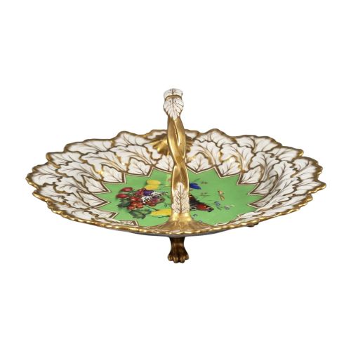 fig 2. A Regency Flight, Barr and Barr Worcester porcelain handle basket featuring a bright green central reserve decorated with hand-painted butterflies and berries, surrounded by a leaf-moulded rim and gilt handle.