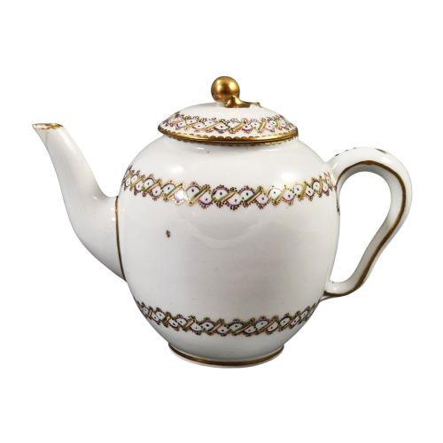 fig 4. A white Sevres porcelain teapot featuring polychrome geometric enamel borders, gilt trim, a rounded body, and a gilded spherical lid finial.