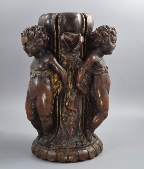 fig 3. A dark carved walnut Italian Baroque torchiere base featuring three sculpted putti figures standing around a central fluted shaft on a gadrooned circular base.