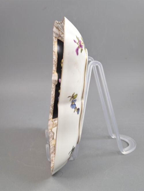 fig 4. A square shaped Meissen porcelain dish decorated with hand-painted Watteau scenes, floral reserves on a black ground, and gilded scroll borders.