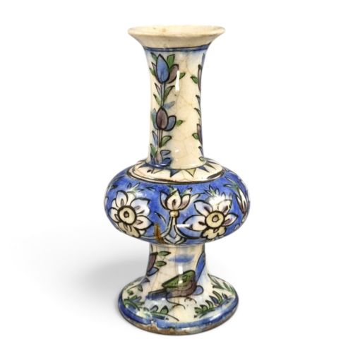 fig 1. A late Qajar Persian polychrome ceramic vase featuring a central bulbous knop, flared rim, crackle glaze finish, and painted blue and green floral motifs.